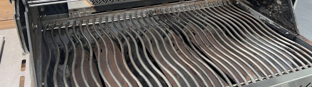 Grill grates soaking in a large tub of eco-friendly degreaser solution as part of HRPM’s barbecue cleaning process.