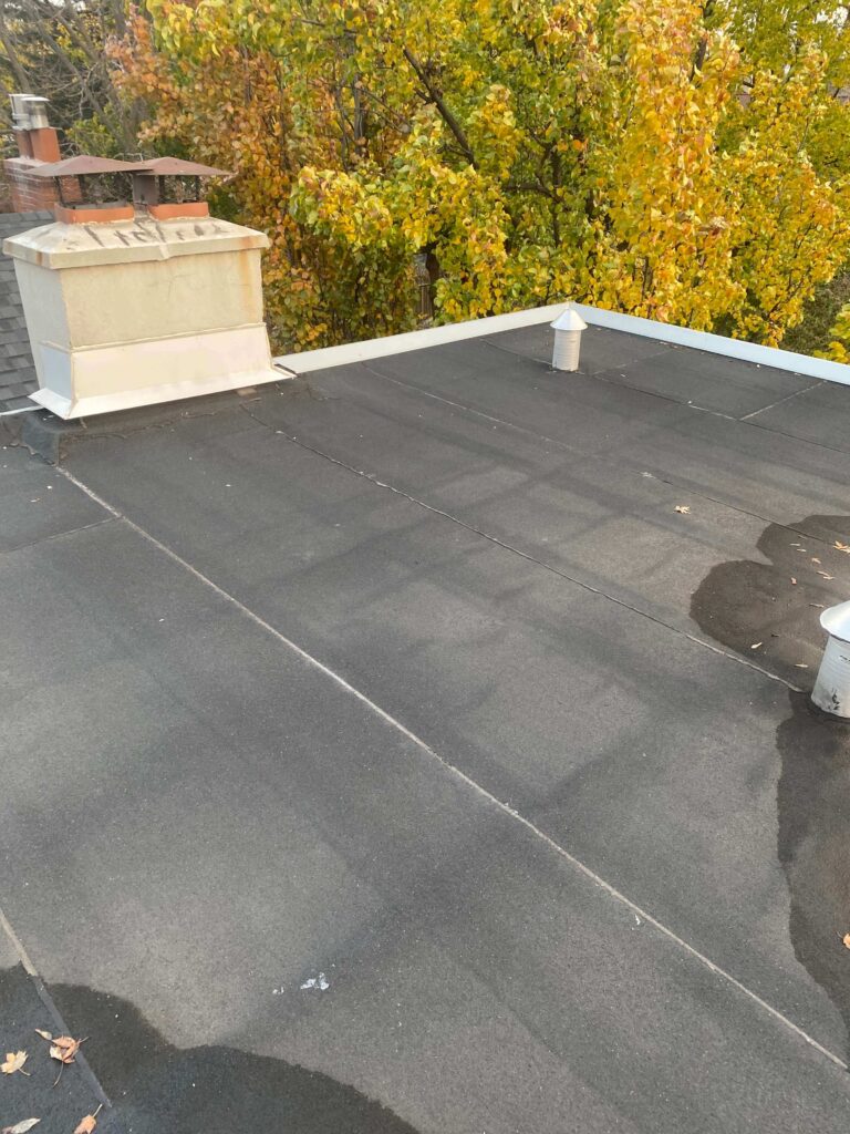 High-pressure rinse being applied to a flat roof membrane to remove stubborn grime, as part of HRPM’s cleaning process.