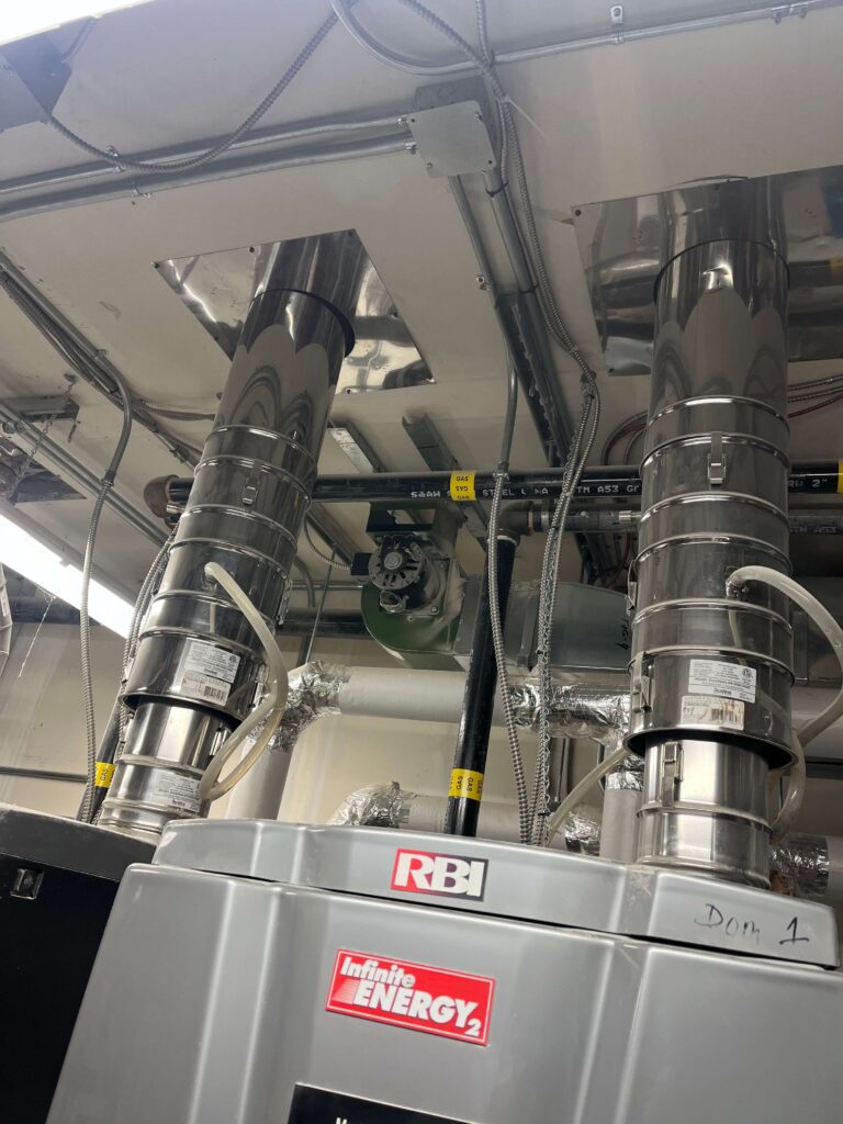Stainless-steel exhaust ducts and piping with accumulated high-level dust before service.