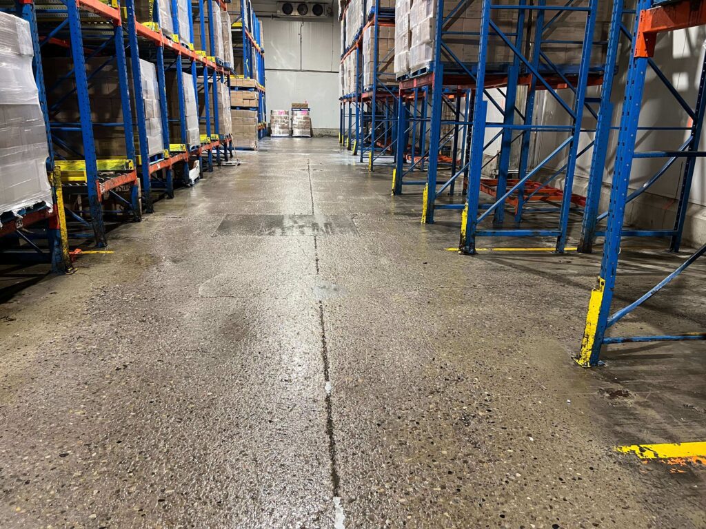 Power washing the exterior of a garage door and surrounding brick façade by HRPM technician.