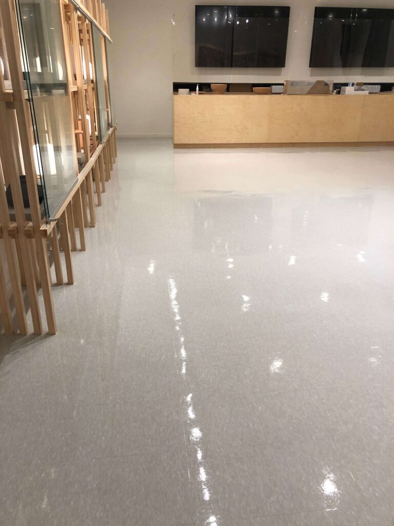 Bright retail showroom floor reflecting shelving and counters