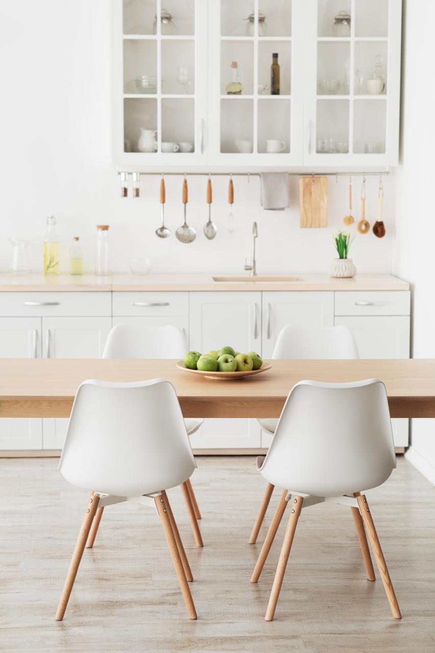 Clean and well-organized kitchen and dining area with spotless countertops and dining table, reflecting high cleanliness standards