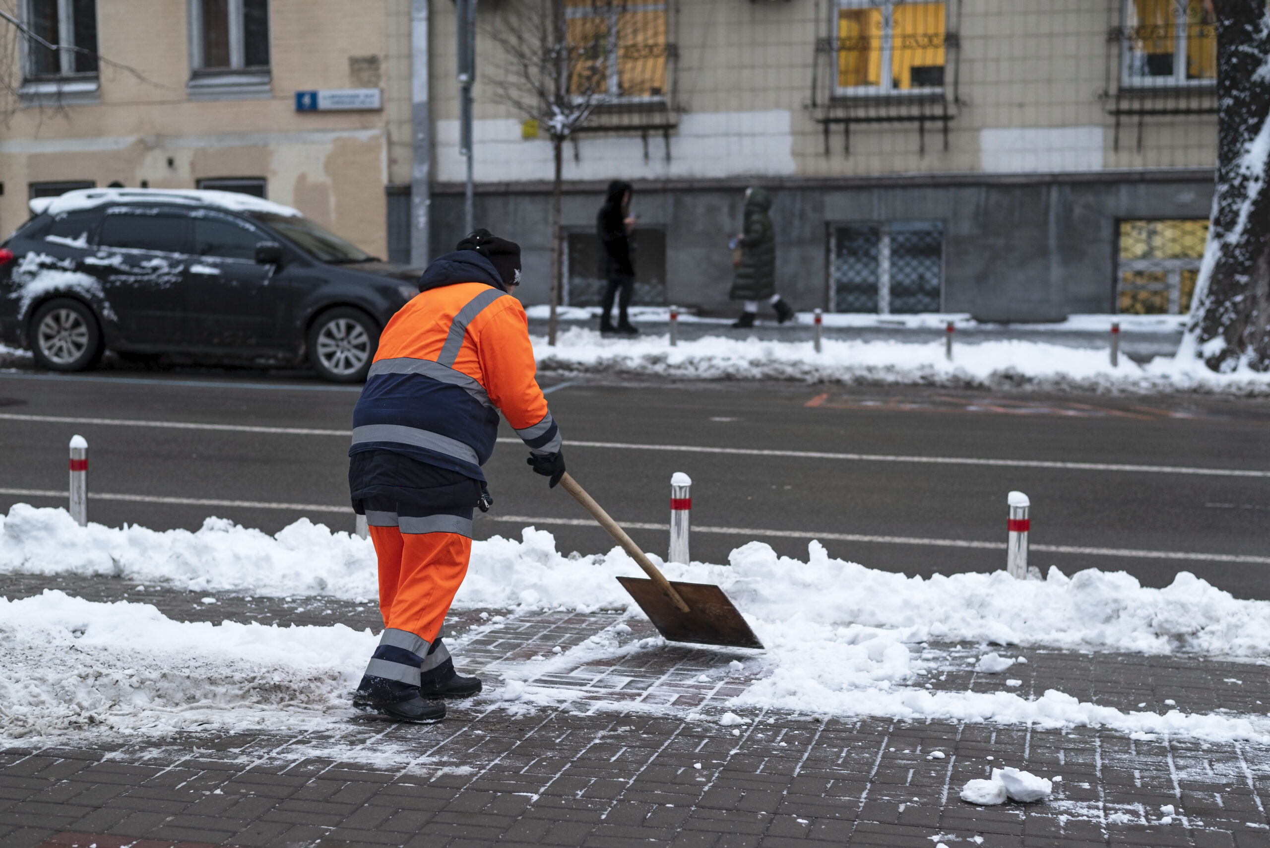 Municipal worker clearing snow from a public sidewalk, illustrating snow removal laws and city responsibilities in the GTA