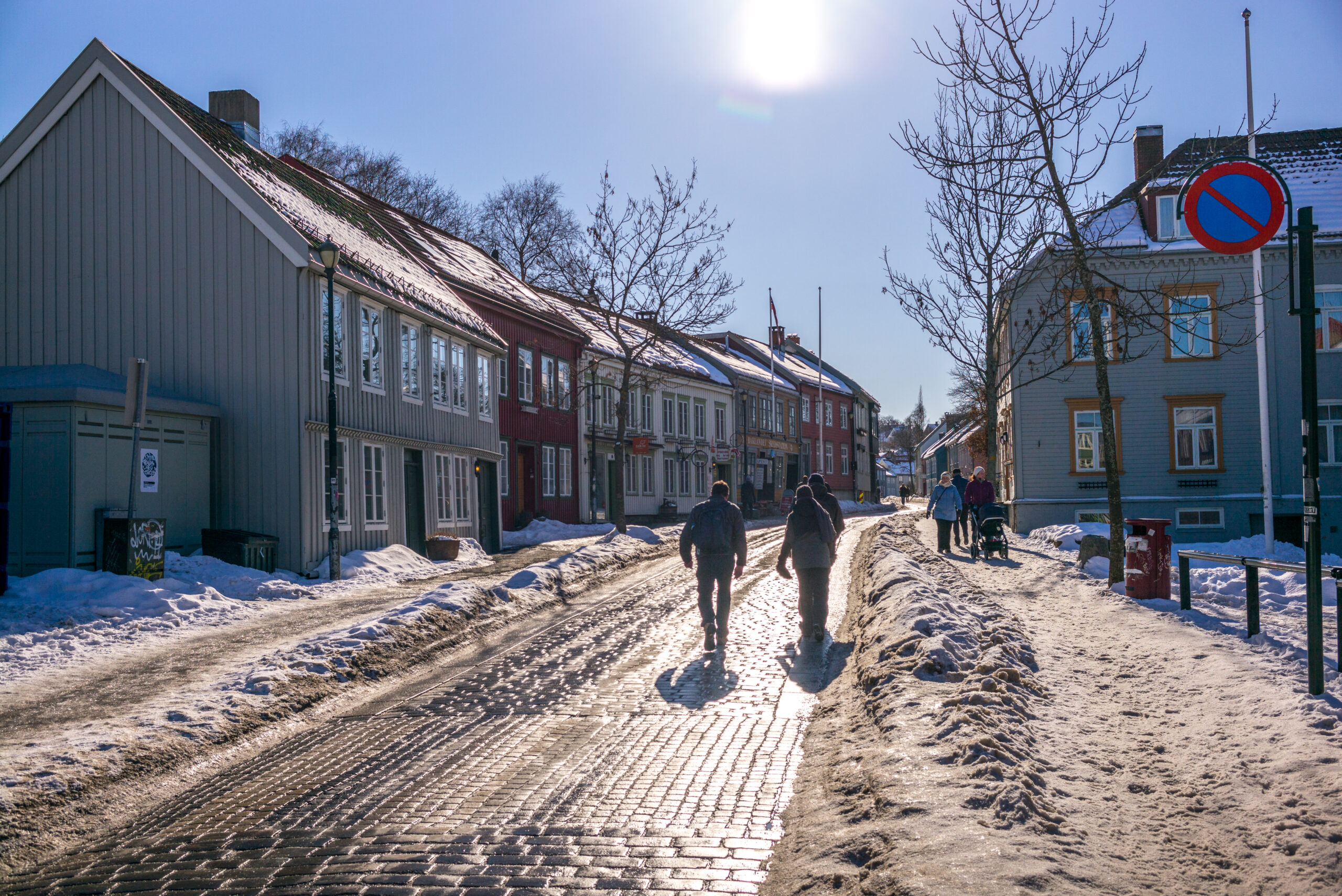 Pedestrians walking along a partially cleared street after snowfall, illustrating snow clearing deadlines and time limits in the GTA